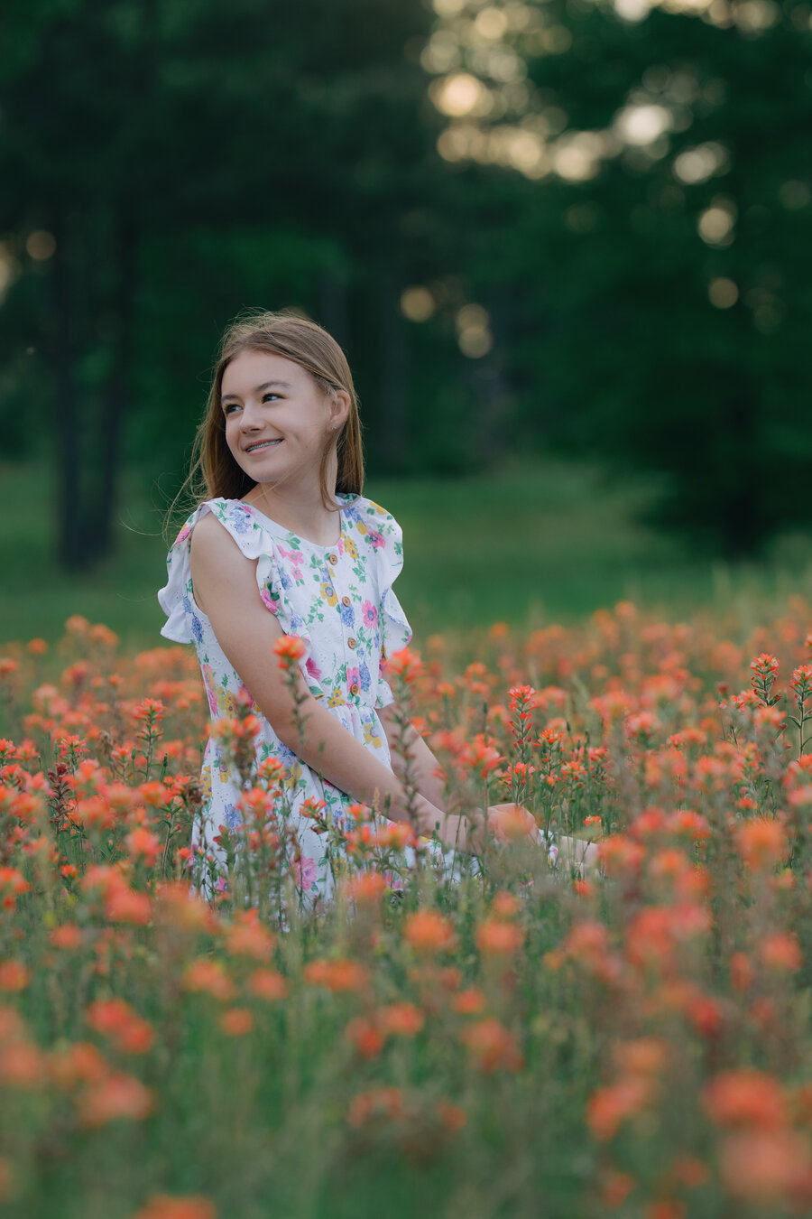 Young woman looking back in a field of wildflowers